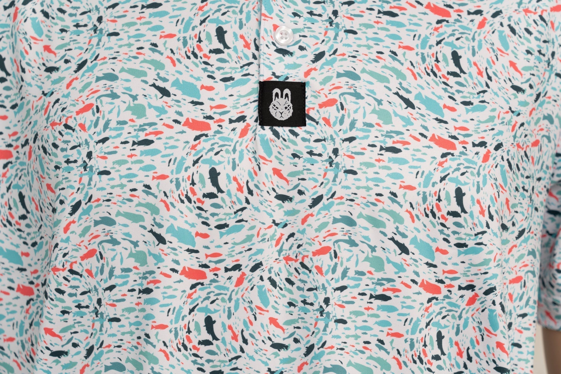 Close-up of button placket, showing structured neckline and subtle branding on the Fish 'n' Chips golf shirt.